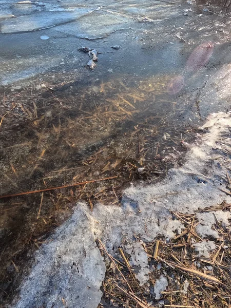 clear ice on the river. ice texture. the ice is melting. spring thaw. frozen water. air and water.