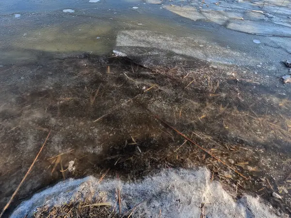 clear ice on the river. ice texture. the ice is melting. spring thaw. frozen water. air and water.