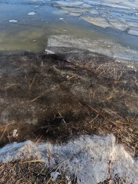clear ice on the river. ice texture. the ice is melting. spring thaw. frozen water. air and water.
