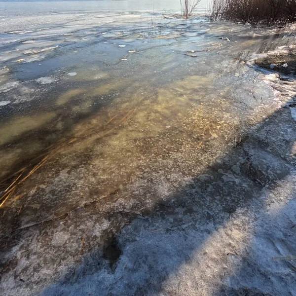 clear ice on the river. ice texture. the ice is melting. spring thaw. frozen water. air and water.