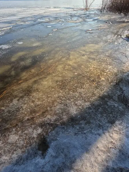 clear ice on the river. ice texture. the ice is melting. spring thaw. frozen water. air and water.