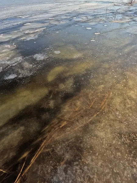 clear ice on the river. ice texture. the ice is melting. spring thaw. frozen water. air and water.