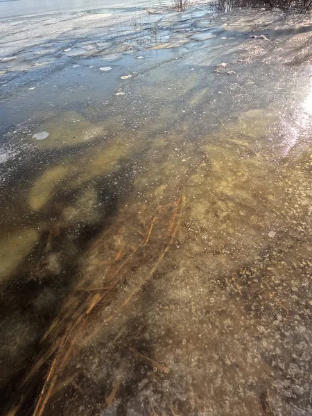 clear ice on the river. ice texture. the ice is melting. spring thaw. frozen water. air and water.