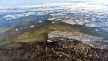 clear ice on the river. ice texture. the ice is melting. spring thaw. frozen water. air and water.