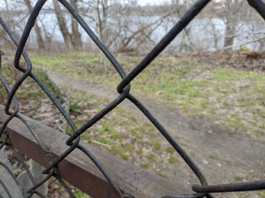 steel mesh. mesh fence. Mesh fence in the city, blurred silhouettes of buildings on the background.