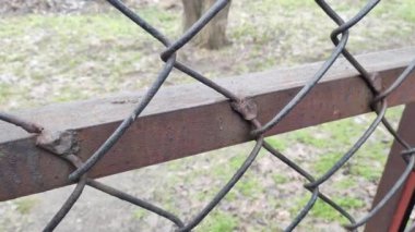 steel mesh. mesh fence. Mesh fence in the city, blurred silhouettes of buildings on the background.