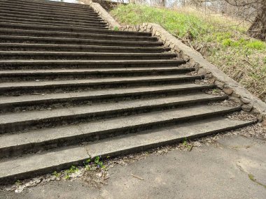 Eski beton merdivenler. Merdivenlerde kuru yapraklar var. Kameralar kuru meşe yapraklarıyla kaplı merdivenlerden yukarı kayıyor. Ağır çekim yakın çekim. Yerde yatan sonbahar yeşilliğinin ayrıntılı hareketli görüntüsü.