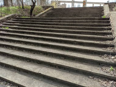 Eski beton merdivenler. Merdivenlerde kuru yapraklar var. Kameralar kuru meşe yapraklarıyla kaplı merdivenlerden yukarı kayıyor. Ağır çekim yakın çekim. Yerde yatan sonbahar yeşilliğinin ayrıntılı hareketli görüntüsü.