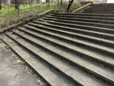 Eski beton merdivenler. Merdivenlerde kuru yapraklar var. Kameralar kuru meşe yapraklarıyla kaplı merdivenlerden yukarı kayıyor. Ağır çekim yakın çekim. Yerde yatan sonbahar yeşilliğinin ayrıntılı hareketli görüntüsü.