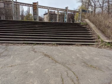 Eski beton merdivenler. Merdivenlerde kuru yapraklar var. Kameralar kuru meşe yapraklarıyla kaplı merdivenlerden yukarı kayıyor. Ağır çekim yakın çekim. Yerde yatan sonbahar yeşilliğinin ayrıntılı hareketli görüntüsü.