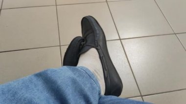Ayakkabılı erkek bacakları. Kot pantolon ve yaz ayakkabıları. Erkekler için deri ayakkabılar.