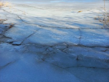 Buz dokusu. Buz saçakları. Kış. Kış havası. Islık ve kar. Buzda çatlaklar var. Donmuş su. şeffaf buz.