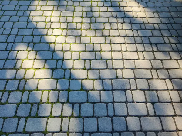 铺路石 砖的质地 路是石头做的 铺路石的纹理 在铺好的街道上的石头上慢慢地循环移动 人行道在城市公园里用铺路石铺成的人行道 — 图库照片