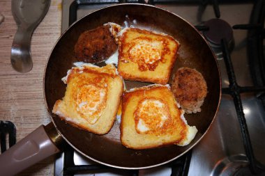 Kızartma tavasında çırpılmış yumurta. Ekmeğin içinde çırpılmış yumurta. Sahanda yumurta. Ev mutfağı. Yemek pişirme.