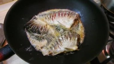Kızarmış balık. Kızartma tavasında balık. Kızarmış nehir balığı. Balık pişirmek. Ev mutfağı. Yemek pişirme.