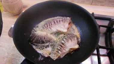 Kızarmış balık. Kızartma tavasında balık. Kızarmış nehir balığı. Balık pişirmek. Ev mutfağı. Yemek pişirme.