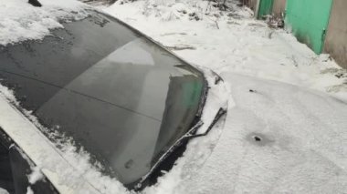 Arabada kar var. Araba karda sıkıştı kaldı. Arabanın farları donduğu için dondu. Araba farları kışın dışarı park ettikten sonra buzla kaplandı. Arabanın farının camında ince bir buz tabakası.