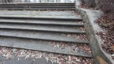 Eski taş merdiven. Bir adam merdivenlerden çıkıyor. Siyah spor ayakkabılı bir adamın bacakları eski bir taş merdiven boyunca yürüyor. Merdivenlerden uzun bir yürüyüş. - Yakın çekim. 4k video