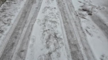 Karda lastik izleri. Buzda donmuş lastikler. Donmuş lastik izleri. Finlandiya 'da donmuş bir gölün üzerindeki araba izleri, havadan çekilmiş. Karda iplikler ve ayak izleri, karla kaplı bir şehir sokağı. 4k