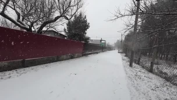 外は雪が降ってる 雪の中にある小さな町の通り 冬の雰囲気について 雪が降った 空からの大きな雪片 — ストック動画