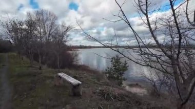 Nehir kıyısında bulutlu bir manzara. Su ve bulutlar. Bulutlu hava manzarası. Dnepr Nehri. Ukrayna. Sonbahar akşamı manzarası. Su ve gökyüzü. Renkli gökyüzü ve ağaçlar durgun sulara yansıyor.