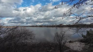 Nehir kıyısında bulutlu bir manzara. Su ve bulutlar. Bulutlu hava manzarası. Dnepr Nehri. Ukrayna. Sonbahar akşamı manzarası. Su ve gökyüzü. Renkli gökyüzü ve ağaçlar durgun sulara yansıyor.