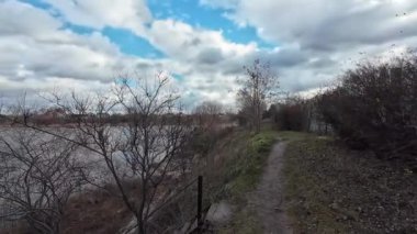 Nehir kıyısında bulutlu bir manzara. Su ve bulutlar. Bulutlu hava manzarası. Dnepr Nehri. Ukrayna. Sonbahar akşamı manzarası. Su ve gökyüzü. Renkli gökyüzü ve ağaçlar durgun sulara yansıyor.