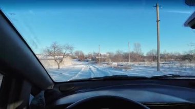 Karlı bir yolda bir arabada. Sürücü karlı havada araba kullanıyor. Kışın araba gezisi. Güneşli bir gün ve karda yol. Karla kaplı bir yolda güneşli bir günde araba sürmek. Tehlikeli buz yolu..