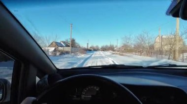 Karlı bir yolda bir arabada. Sürücü karlı havada araba kullanıyor. Kışın araba gezisi. Güneşli bir gün ve karda yol. Karla kaplı bir yolda güneşli bir günde araba sürmek. Tehlikeli buz yolu..