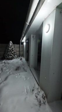 Karda veranda. Geceleri karlı bir bahçe. Şiddetli bir kar yağışı sırasında geceleri arka bahçedeki taraça. Kış sahnesi. Karla kaplı bir gece konutu. Kar yağıyor.
