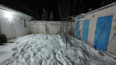 Karda veranda. Geceleri karlı bir bahçe. Şiddetli bir kar yağışı sırasında geceleri arka bahçedeki taraça. Kış sahnesi. Karla kaplı bir gece konutu. Kar yağıyor.