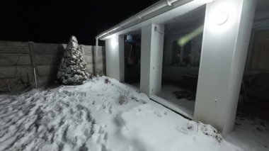 Karda veranda. Geceleri karlı bir bahçe. Şiddetli bir kar yağışı sırasında geceleri arka bahçedeki taraça. Kış sahnesi. Karla kaplı bir gece konutu. Kar yağıyor.