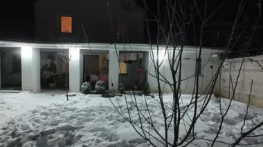 Karda veranda. Geceleri karlı bir bahçe. Şiddetli bir kar yağışı sırasında geceleri arka bahçedeki taraça. Kış sahnesi. Karla kaplı bir gece konutu. Kar yağıyor.