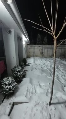 Karda veranda. Geceleri karlı bir bahçe. Şiddetli bir kar yağışı sırasında geceleri arka bahçedeki taraça. Kış sahnesi. Karla kaplı bir gece konutu. Kar yağıyor.