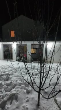 Karda veranda. Geceleri karlı bir bahçe. Şiddetli bir kar yağışı sırasında geceleri arka bahçedeki taraça. Kış sahnesi. Karla kaplı bir gece konutu. Kar yağıyor.