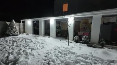 Karda veranda. Geceleri karlı bir bahçe. Şiddetli bir kar yağışı sırasında geceleri arka bahçedeki taraça. Kış sahnesi. Karla kaplı bir gece konutu. Kar yağıyor.