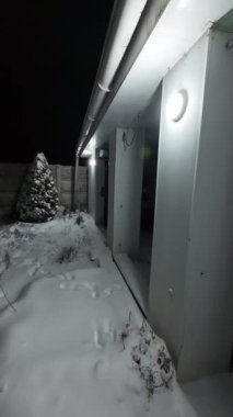Karda veranda. Geceleri karlı bir bahçe. Şiddetli bir kar yağışı sırasında geceleri arka bahçedeki taraça. Kış sahnesi. Karla kaplı bir gece konutu. Kar yağıyor.