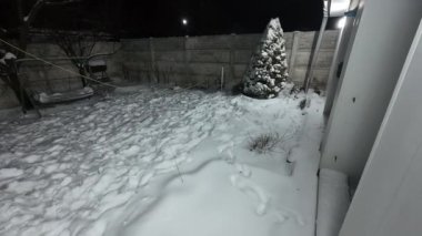Karda veranda. Geceleri karlı bir bahçe. Şiddetli bir kar yağışı sırasında geceleri arka bahçedeki taraça. Kış sahnesi. Karla kaplı bir gece konutu. Kar yağıyor.