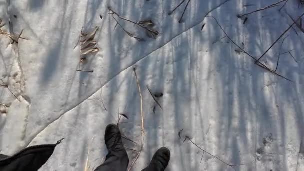 川の上の氷 凍った川を歩く 男は雪と氷の上を歩いている 危ない氷 凍結する水 氷の中の深い亀裂 川のある冬の晴れた風景 冬の川と太陽 — ストック動画