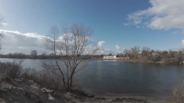 Nehir kıyısındaki manzara. Dnepr Nehri. Ukrayna manzarası. Nehirde güçlü bir rüzgar var. Güzel bulutlar. Mavi gökyüzü ve suyla birlikte manzara. Sahilde açık bir günde doğal manzara.
