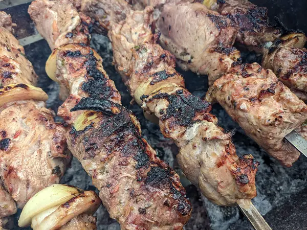Barbeküde ızgara lezzetli yemeklere yakın çekim. Doğada lezzetli şiş kebap pişirme süreci. BBC 'deki metal şişte lezzetli yemekler. Piknik zamanı. Sokak yemeği. Yemek festivali. shashlik.