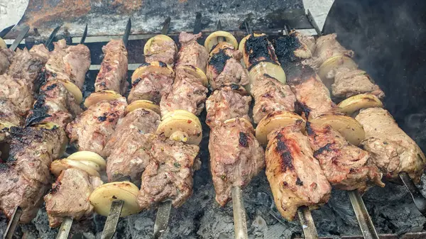 Barbeküde ızgara lezzetli yemeklere yakın çekim. Doğada lezzetli şiş kebap pişirme süreci. BBC 'deki metal şişte lezzetli yemekler. Piknik zamanı. Sokak yemeği. Yemek festivali. shashlik.