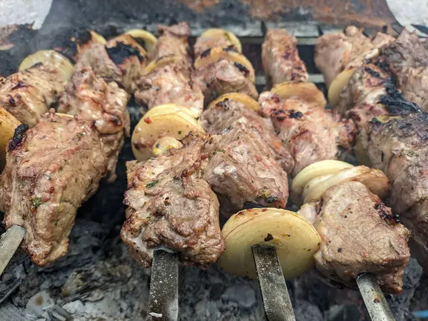 Barbeküde ızgara lezzetli yemeklere yakın çekim. Doğada lezzetli şiş kebap pişirme süreci. BBC 'deki metal şişte lezzetli yemekler. Piknik zamanı. Sokak yemeği. Yemek festivali. shashlik.