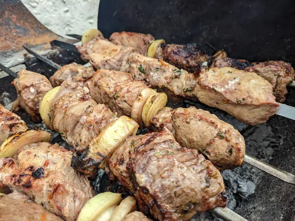 Barbeküde ızgara lezzetli yemeklere yakın çekim. Doğada lezzetli şiş kebap pişirme süreci. BBC 'deki metal şişte lezzetli yemekler. Piknik zamanı. Sokak yemeği. Yemek festivali. shashlik.