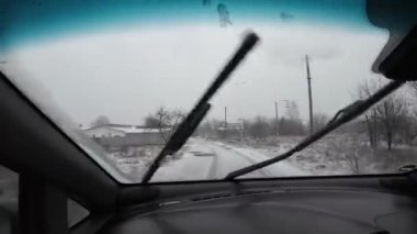 Şoför araba kullanıyor. Kötü yol. Yoldaki çukurlar. Kötü yol koşulları. Yoğun kar yağışı sırasında başka bir arabanın yanından geçen POV çalışanı.