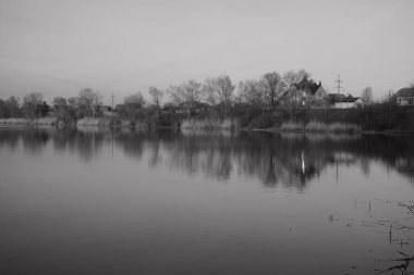 Tek renkli su manzarası var. Suda yansıması olan siyah ve beyaz bir manzara. Nehirdeki vahşi doğa manzarası.
