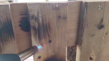 Dervea ve ateş dokusu. Ateş ve tahtalar. Ahşap ateş tedavisi. Kullan at odun yakıyor. İç mekan için gaz ocağıyla dekoratif ateş. Büyücü ağacı ateşle işliyor.