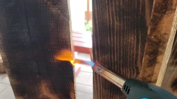 デルヴェアと火の質感について 火とボード 木の火の処置 バーナーは木製のボードを燃やしています 内部のためのガスバーナーで装飾的な発射 魔法使いは木を火で処理する — ストック動画