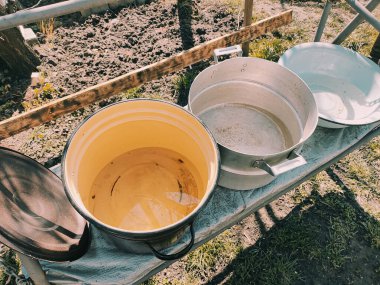 Birkaç boş tava. Büyük kaplar dolusu su. bir sürü renkli tencere.