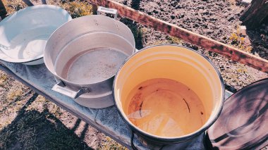 Birkaç boş tava. Büyük kaplar dolusu su. bir sürü renkli tencere.